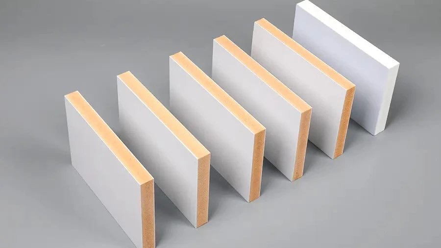 Cross-section edge detail of PVC co-extrusion board showing thin white cap layer bonded to darker foam core with uniform interface line Cross-section edge detail of PVC co-extrusion board showing thin white cap layer bonded to darker foam core with uniform interface line